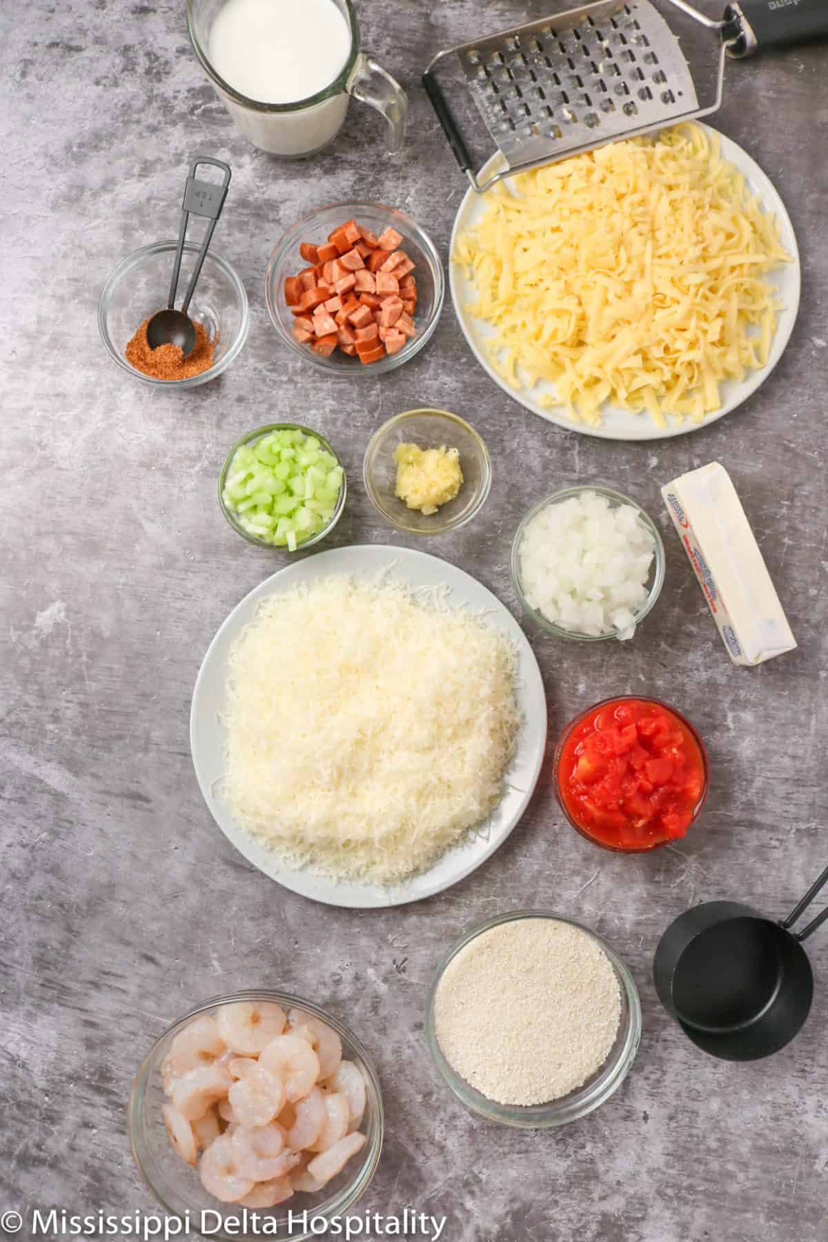 ingredients for shrimp and grits on a concrete board.