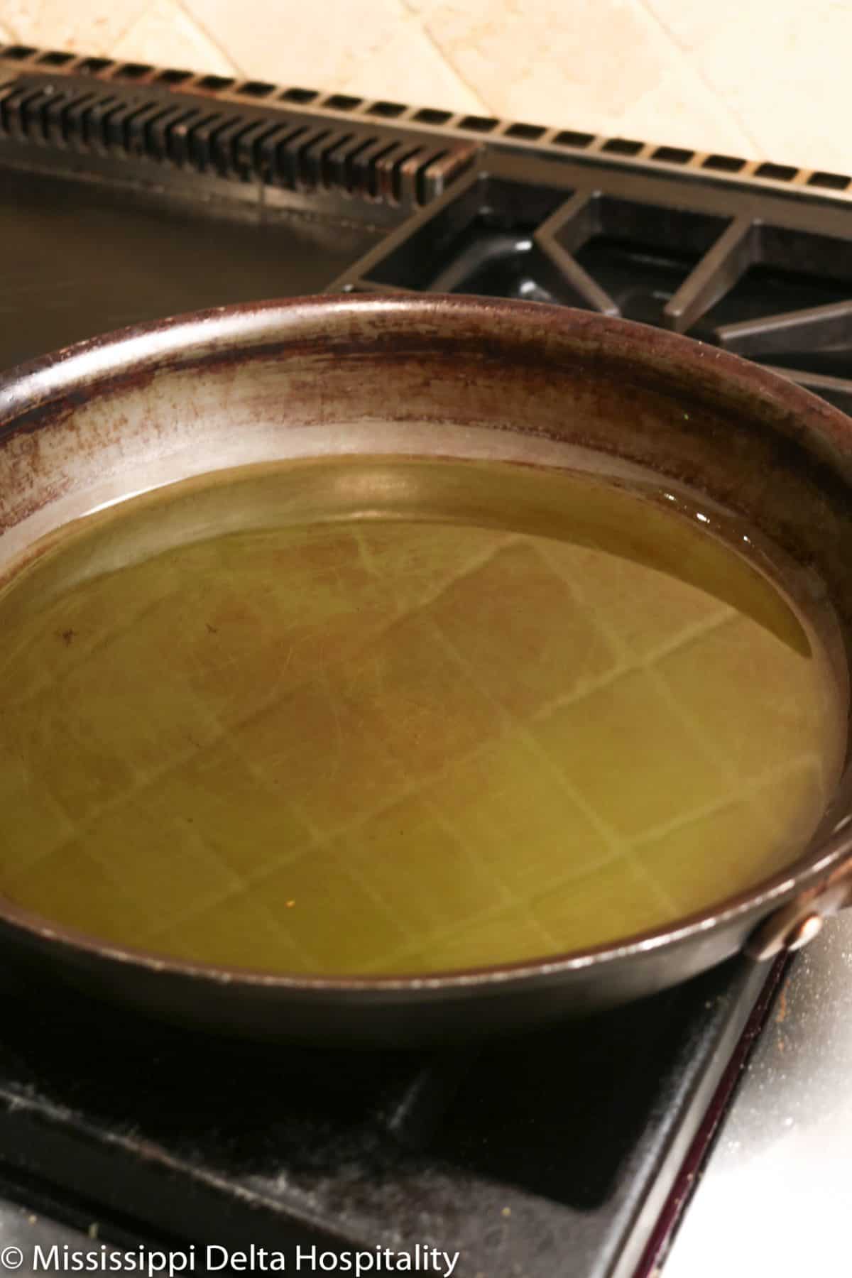 a pan with oil on a gas stove top