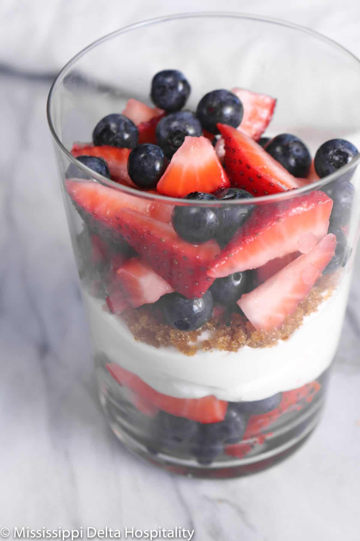 berries on top of layers of whipped cream and brown sugar
