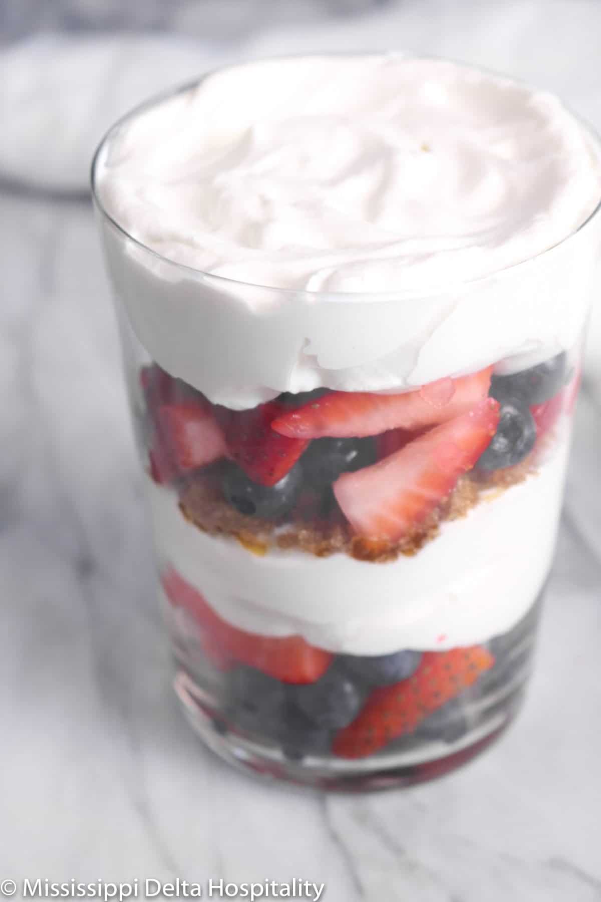 whipped cream on top of the last layer of berries