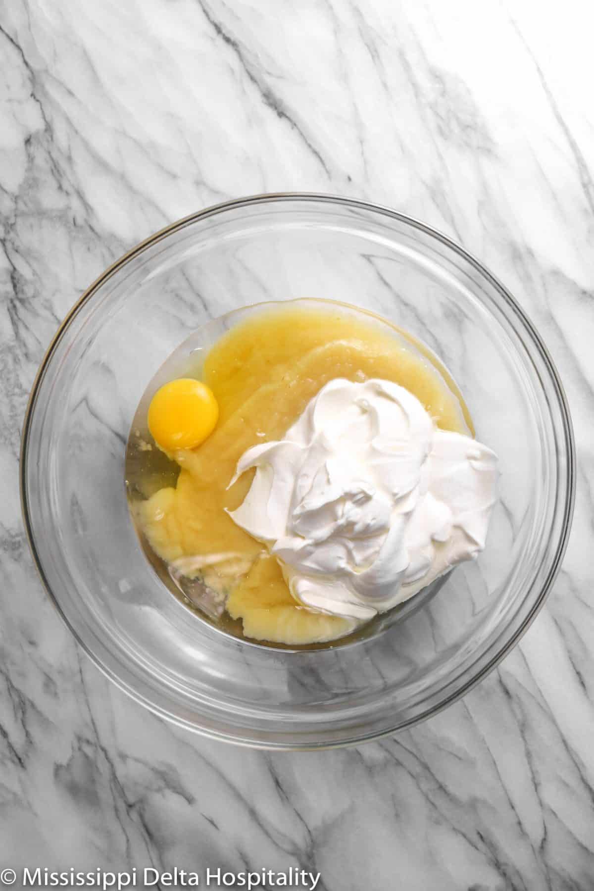 sour cream, an egg, apple sauce, and vegetable oil in a glass bowl