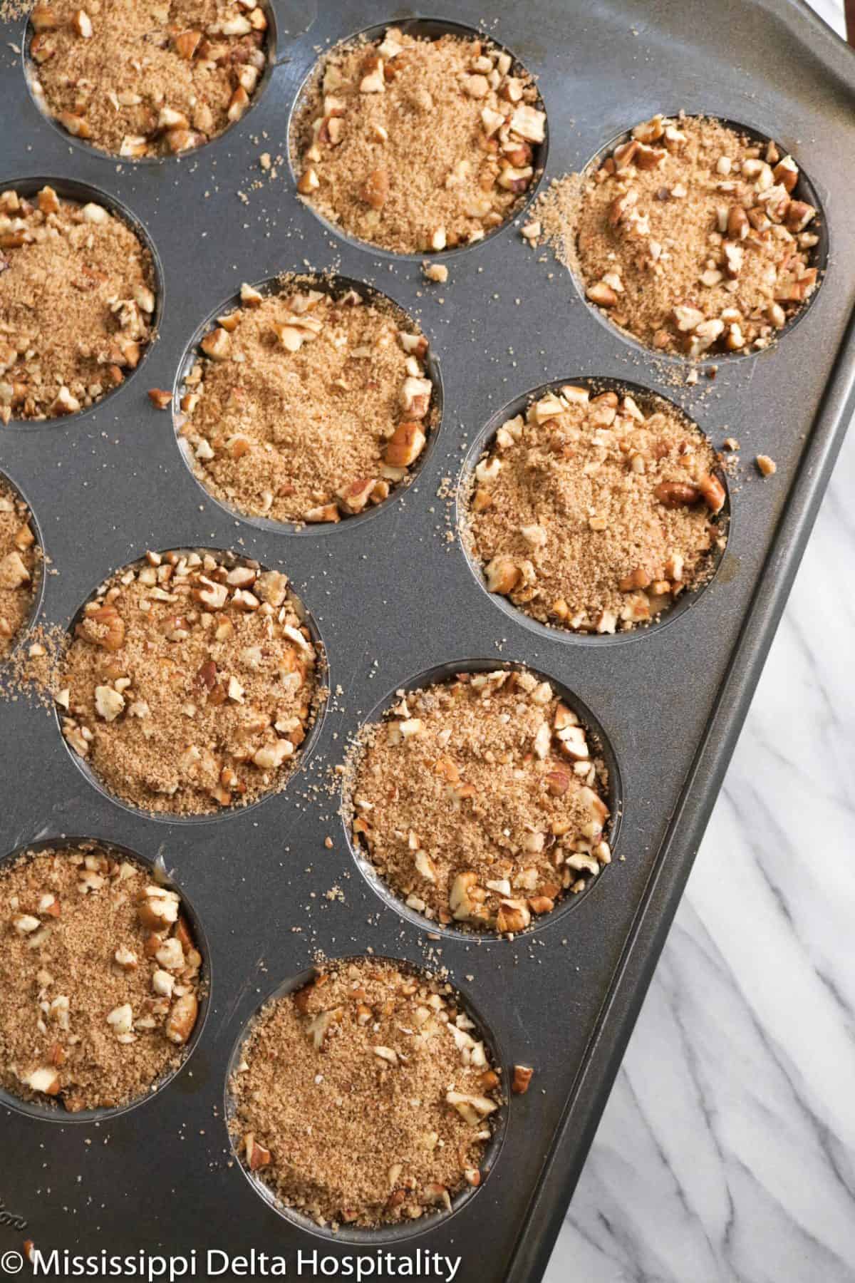 apple cinnamon muffins in a pan with streusel on top