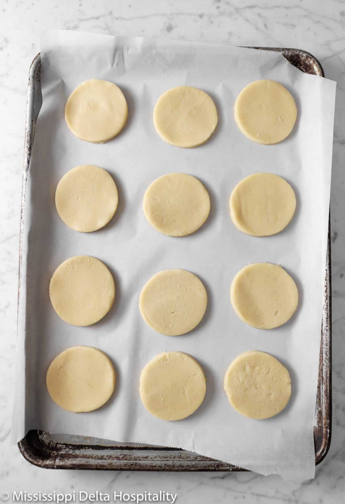 a lined sheet pan with sugar cookies