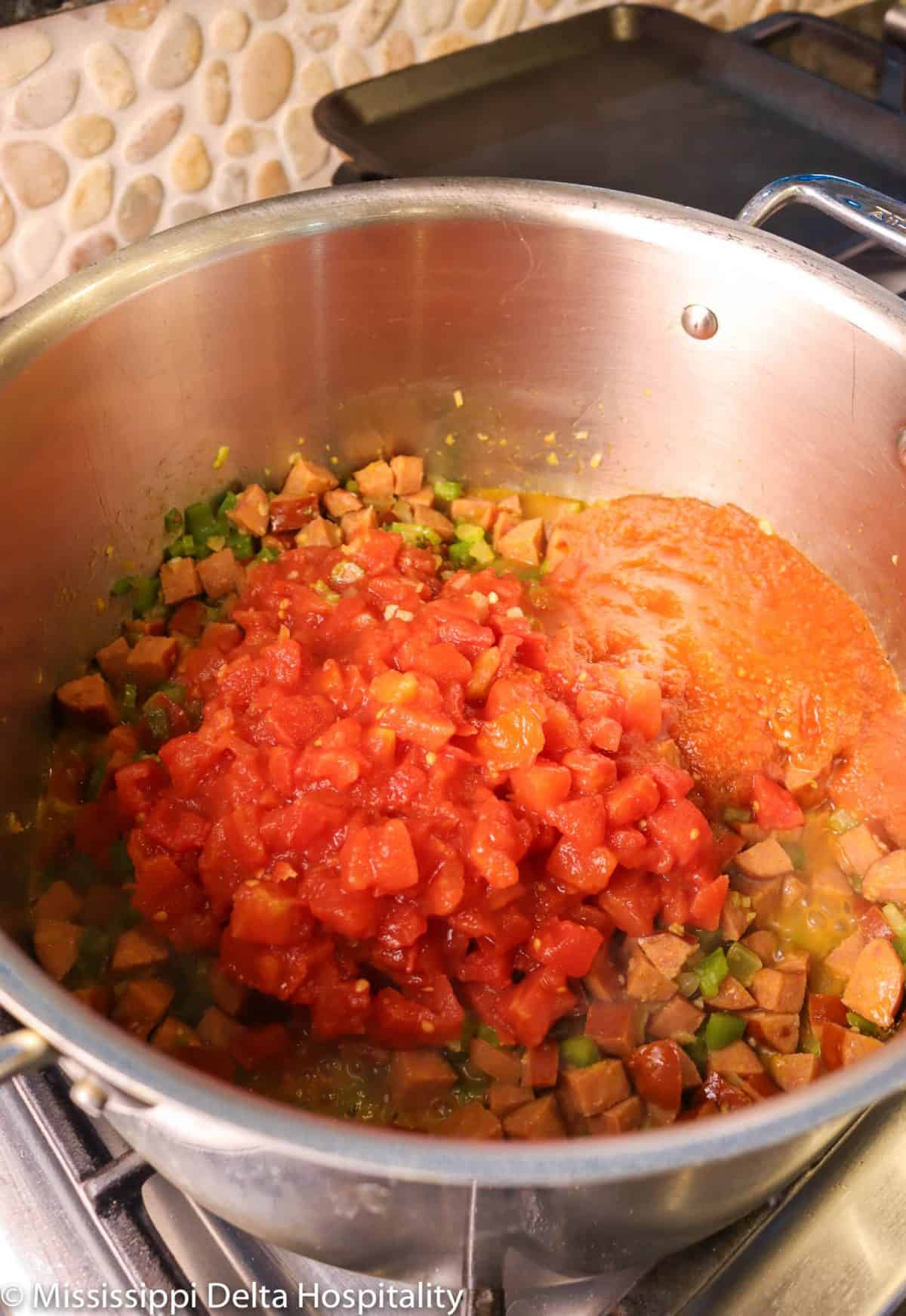 tomatoes and tomato sauce added to pot