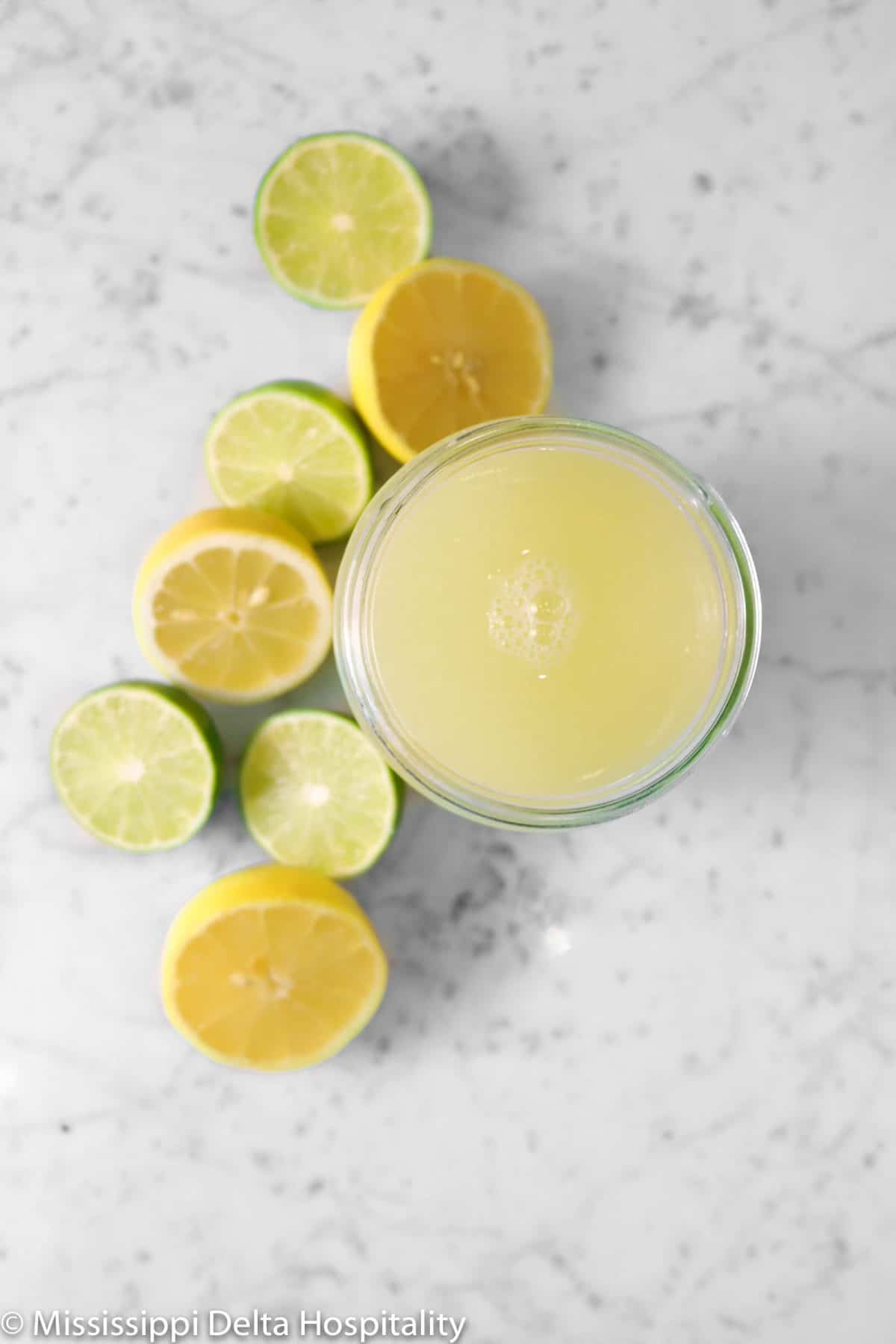 sour mix on a marble board with lemons and limes