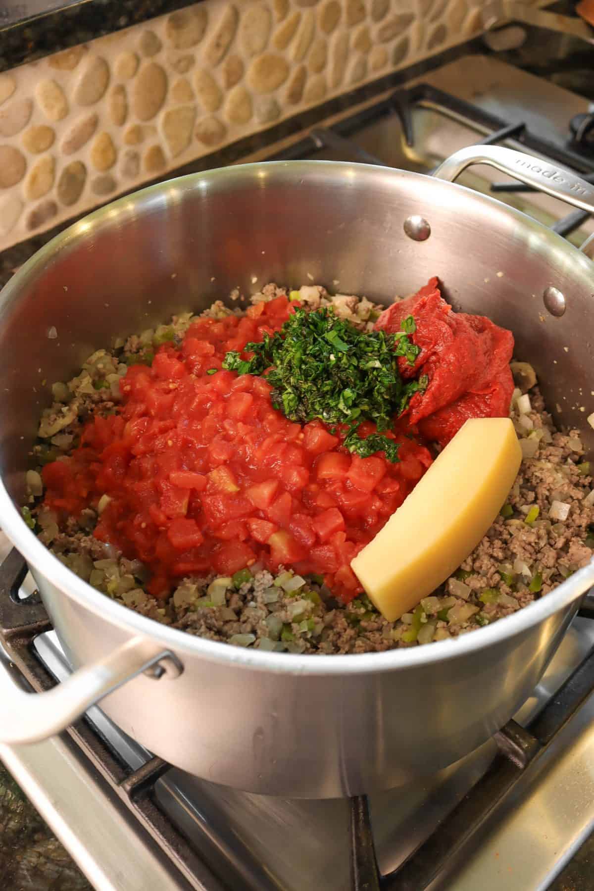 parmesan rind, tomatoes, and herbs added to ground beeef mixture