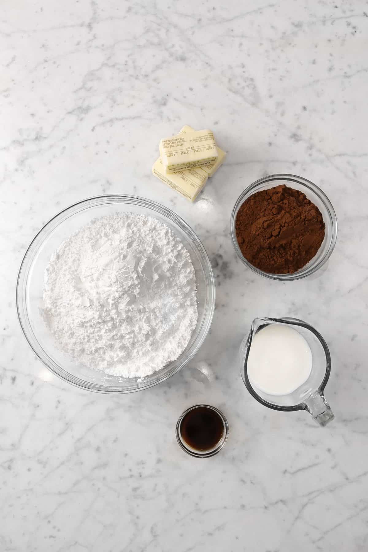 ingredients for chocolate frosting on a marble counter