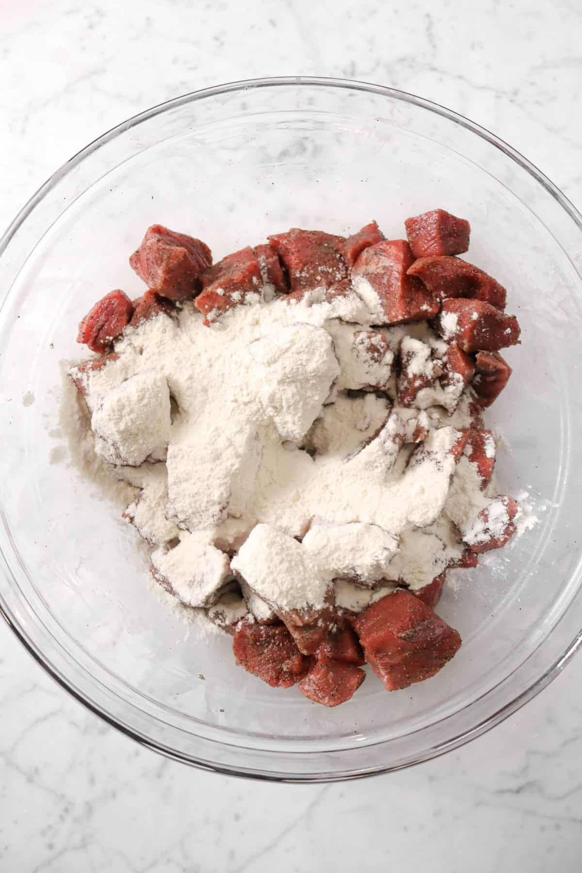 meat and flour in a glass bowl