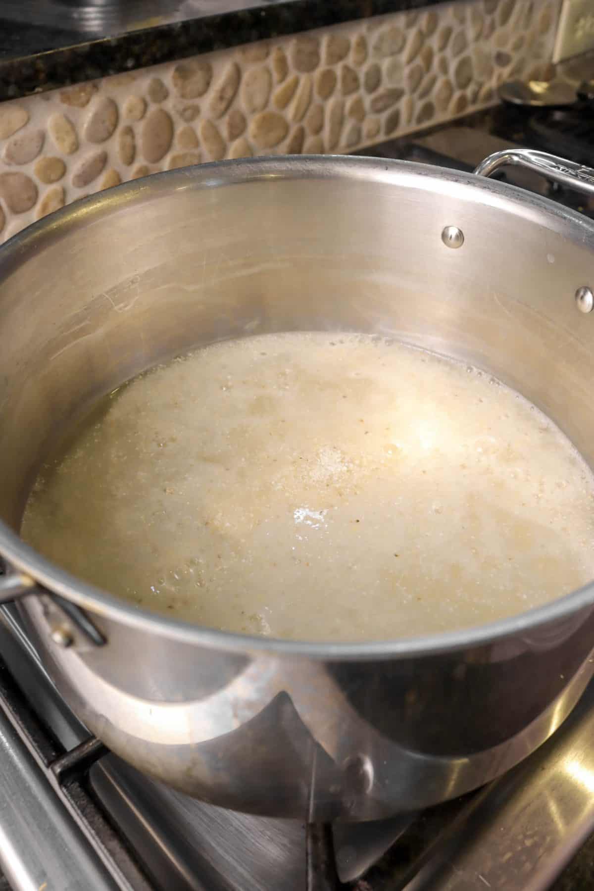 grits added to boiling water in a pot
