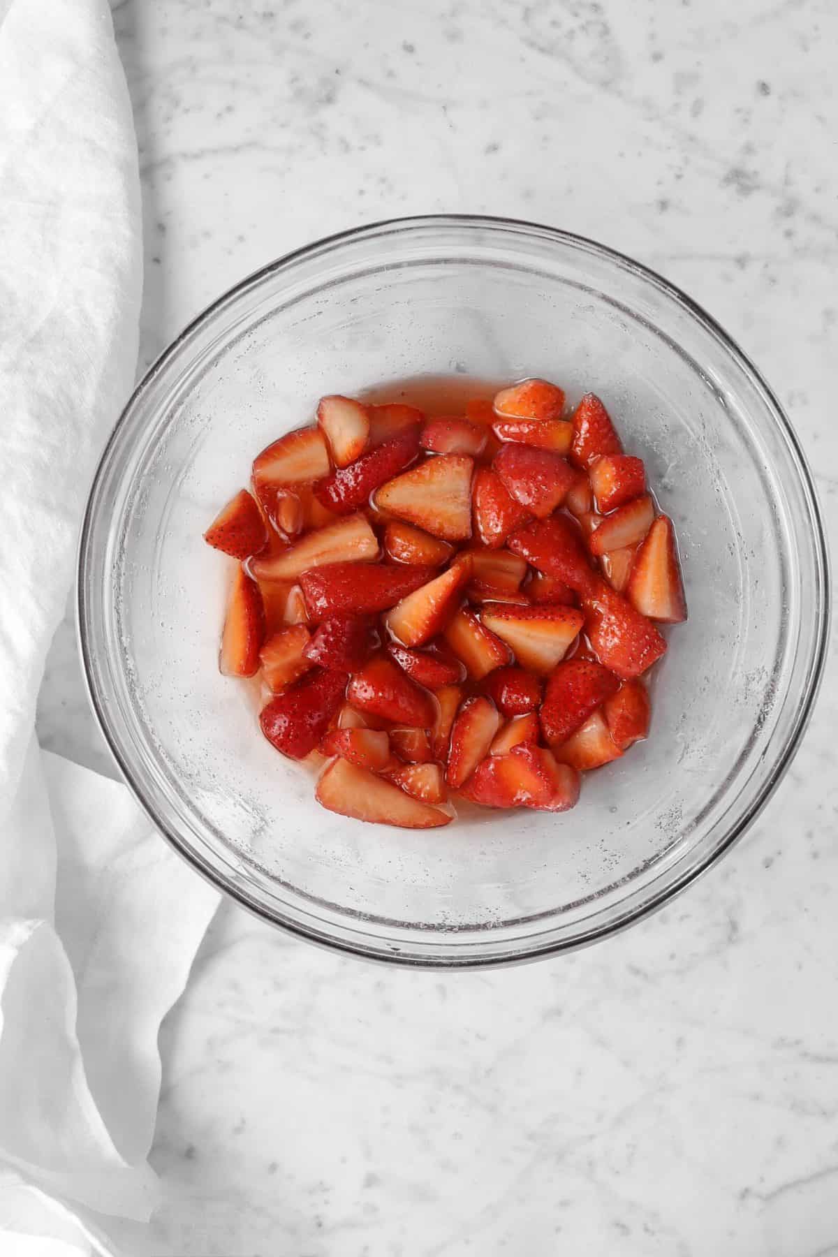 macerated strawberries in a glass bowl with a white napkin