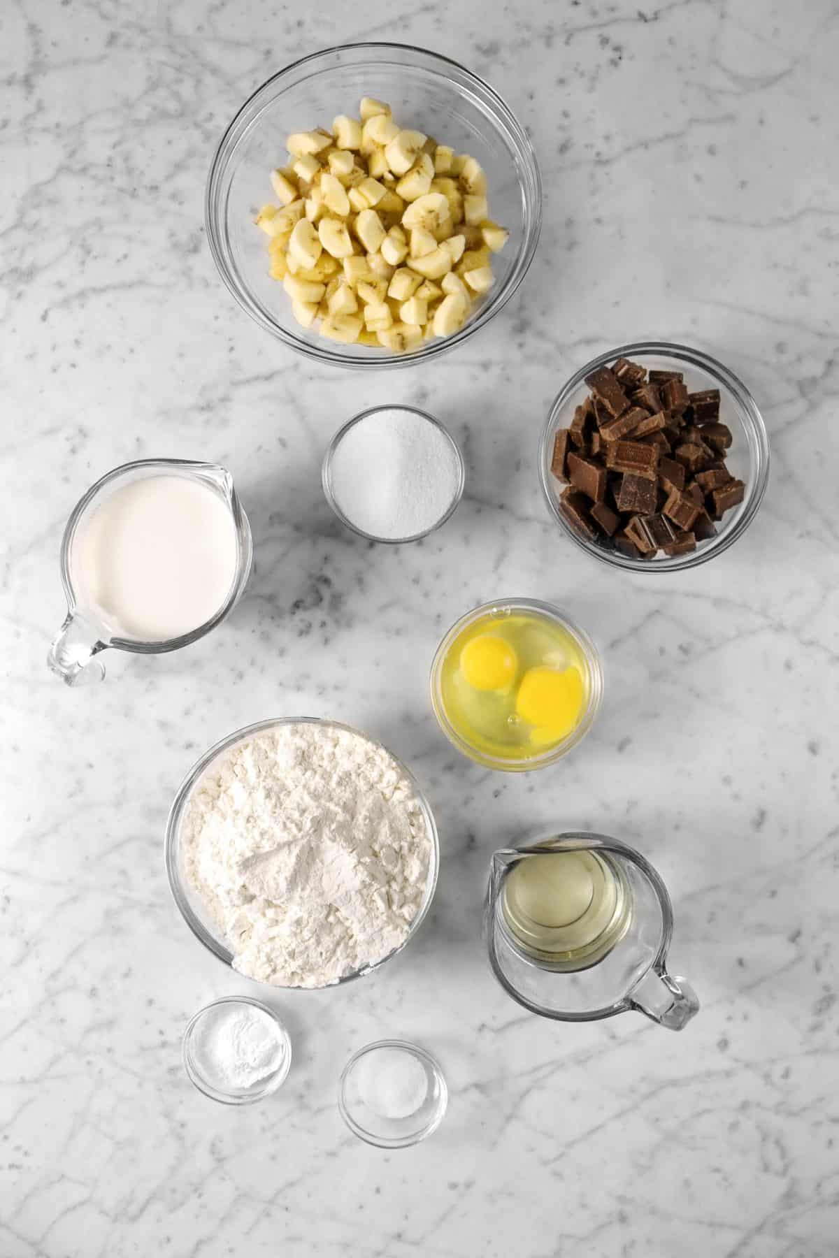 ingredients for chocolate chunk banana muffins on a marble counter
