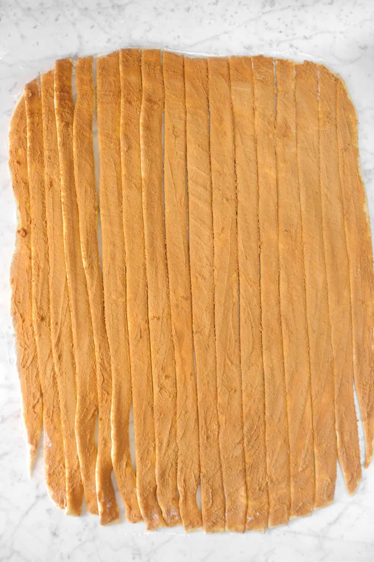 cinnamon roll dough cut into length wise strips