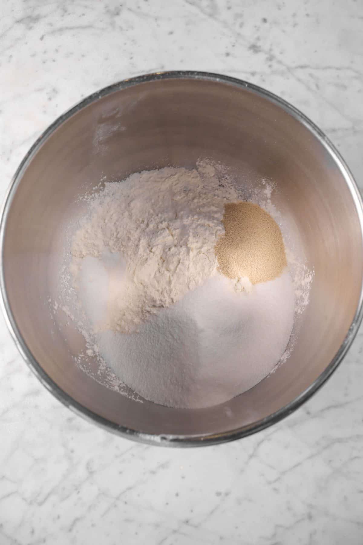 mixer bowl with flour, yeast, salt, and sugar