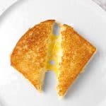 grilled cheese on a white plate that's sliced in half