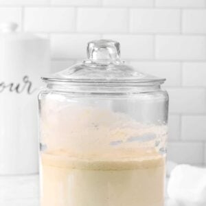 sourdough starter in a glass jar with a white napkin