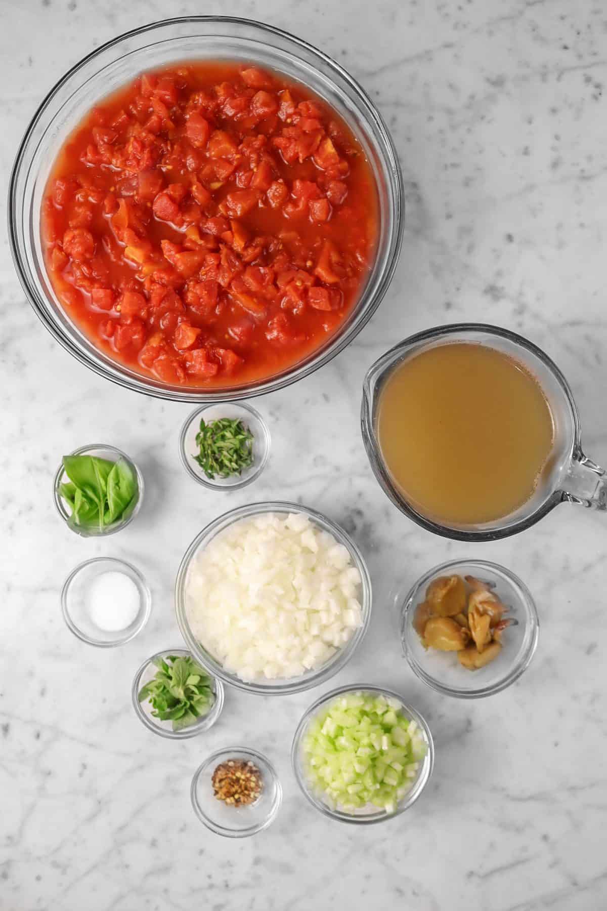 ingredients for tomato soup on a marble counter