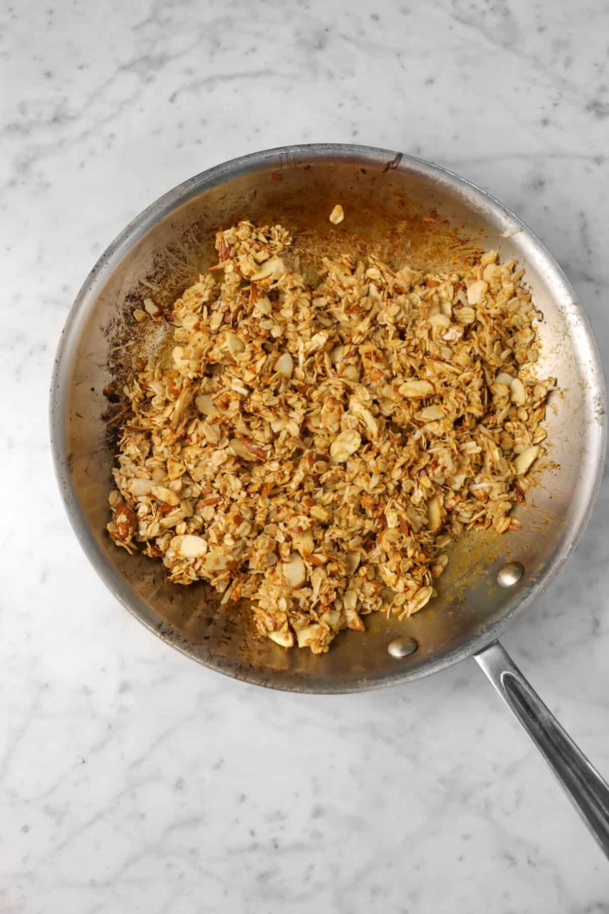 granola in a sauté pan on a marble counter