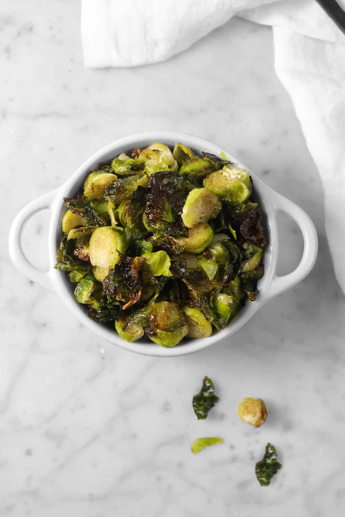 overhead shot of roasted brussel sprouts in a white cocotte