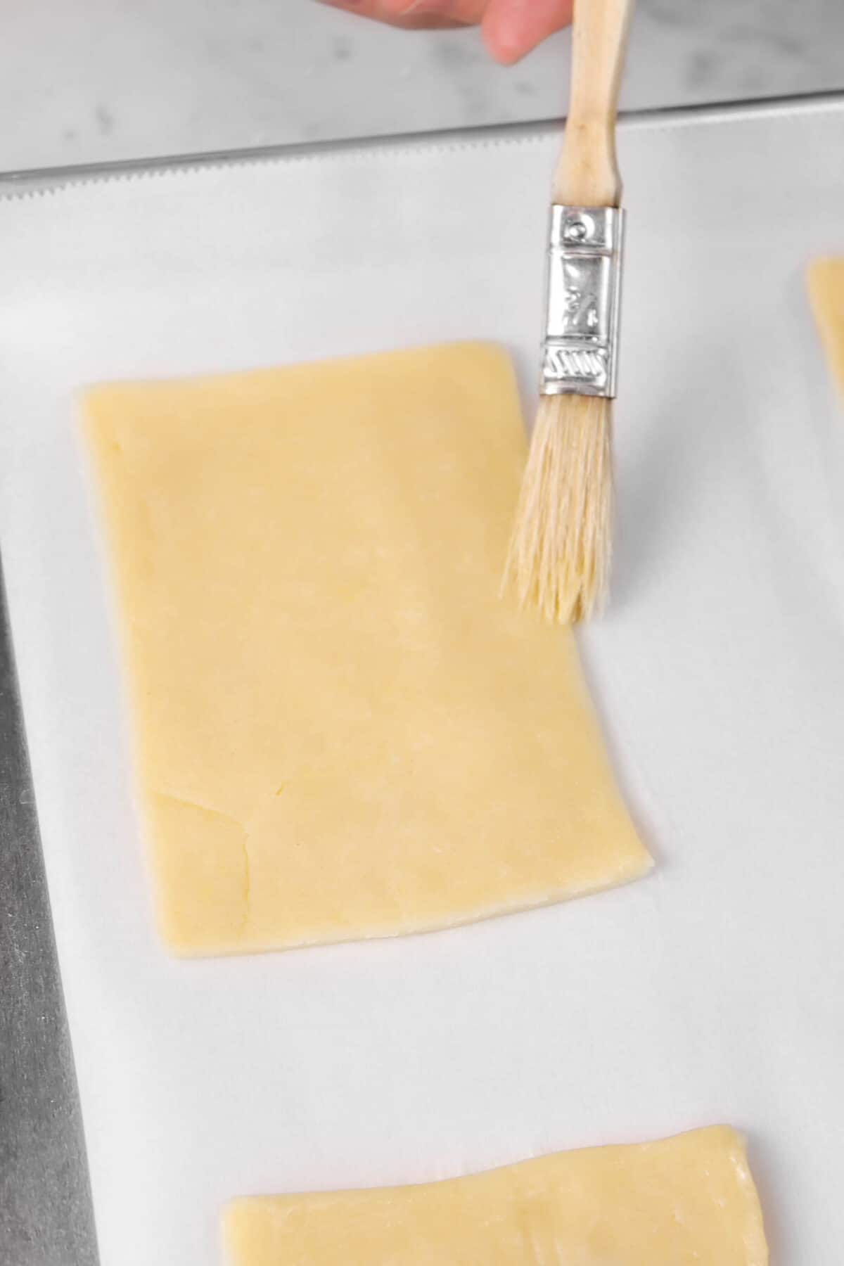 pie dough being brushed with egg wash