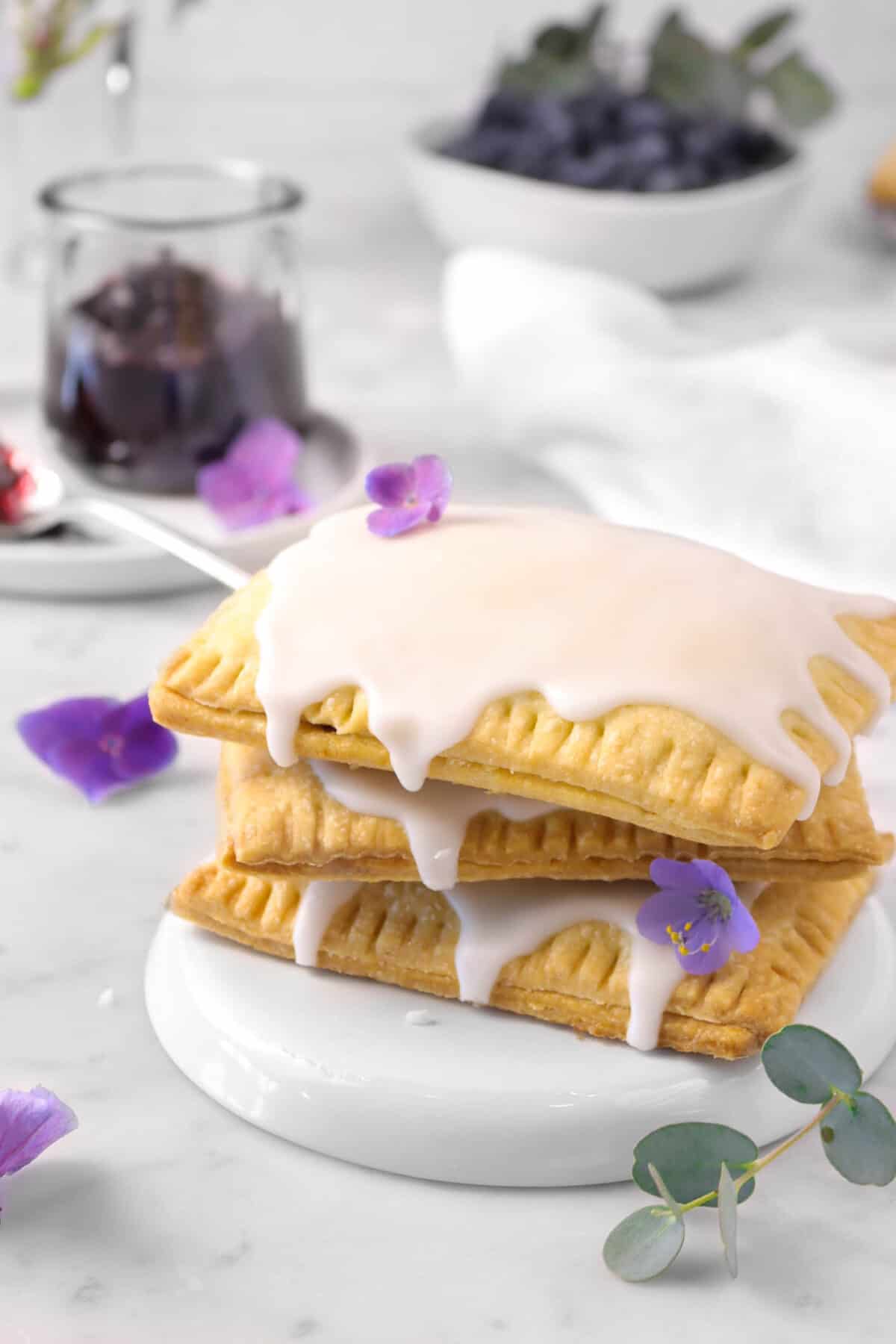 three pop tarts stacked with flowers, eucalyptus, and a jar of jam