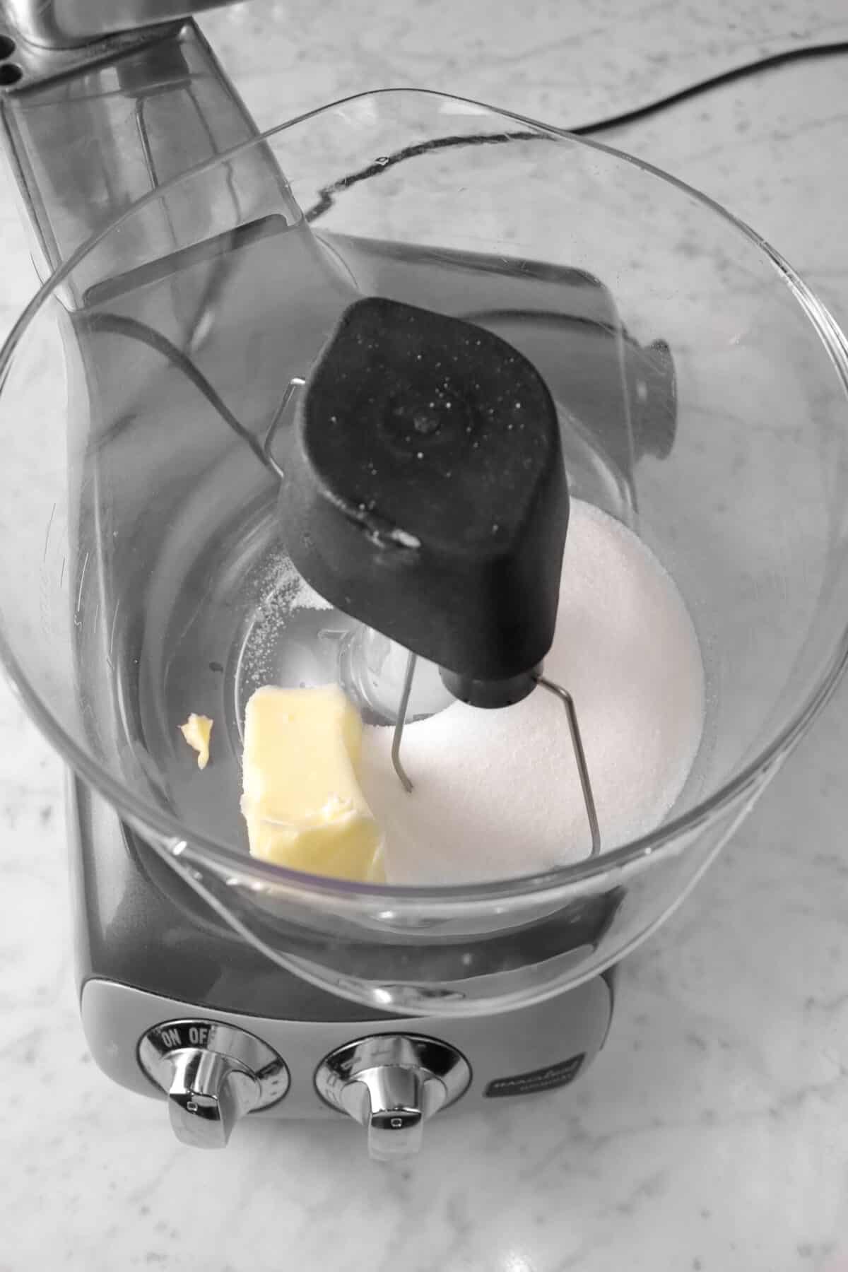 butter and sugar in a mixer on a marble board