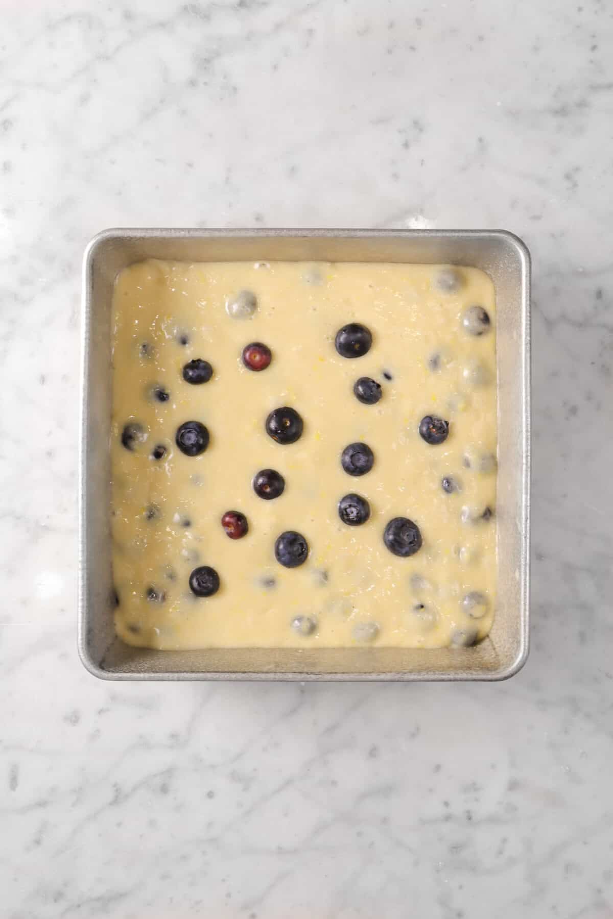 lemon blueberry cake batter in a square cake pan
