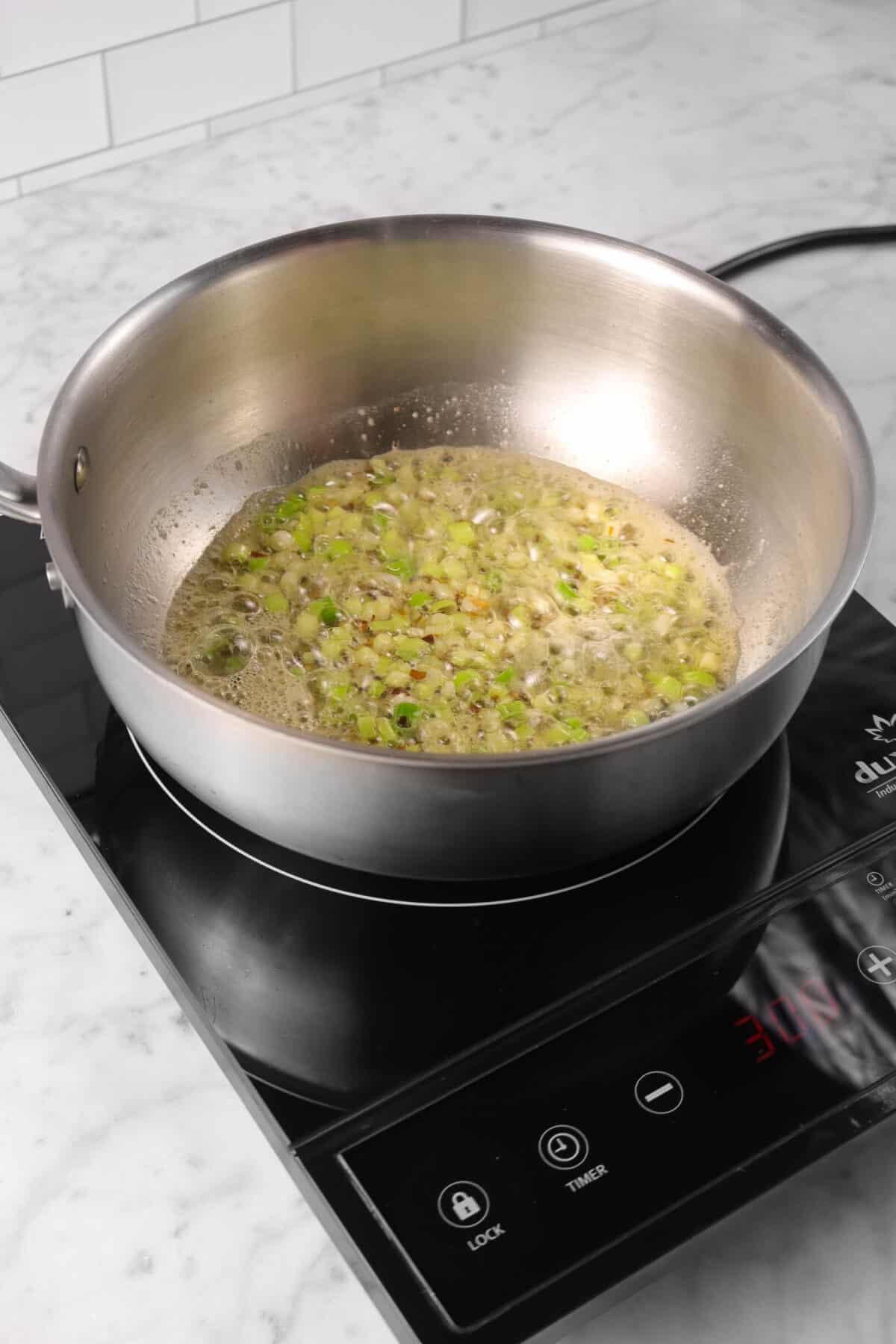 green onions, pepper flakes, and butter in a pot