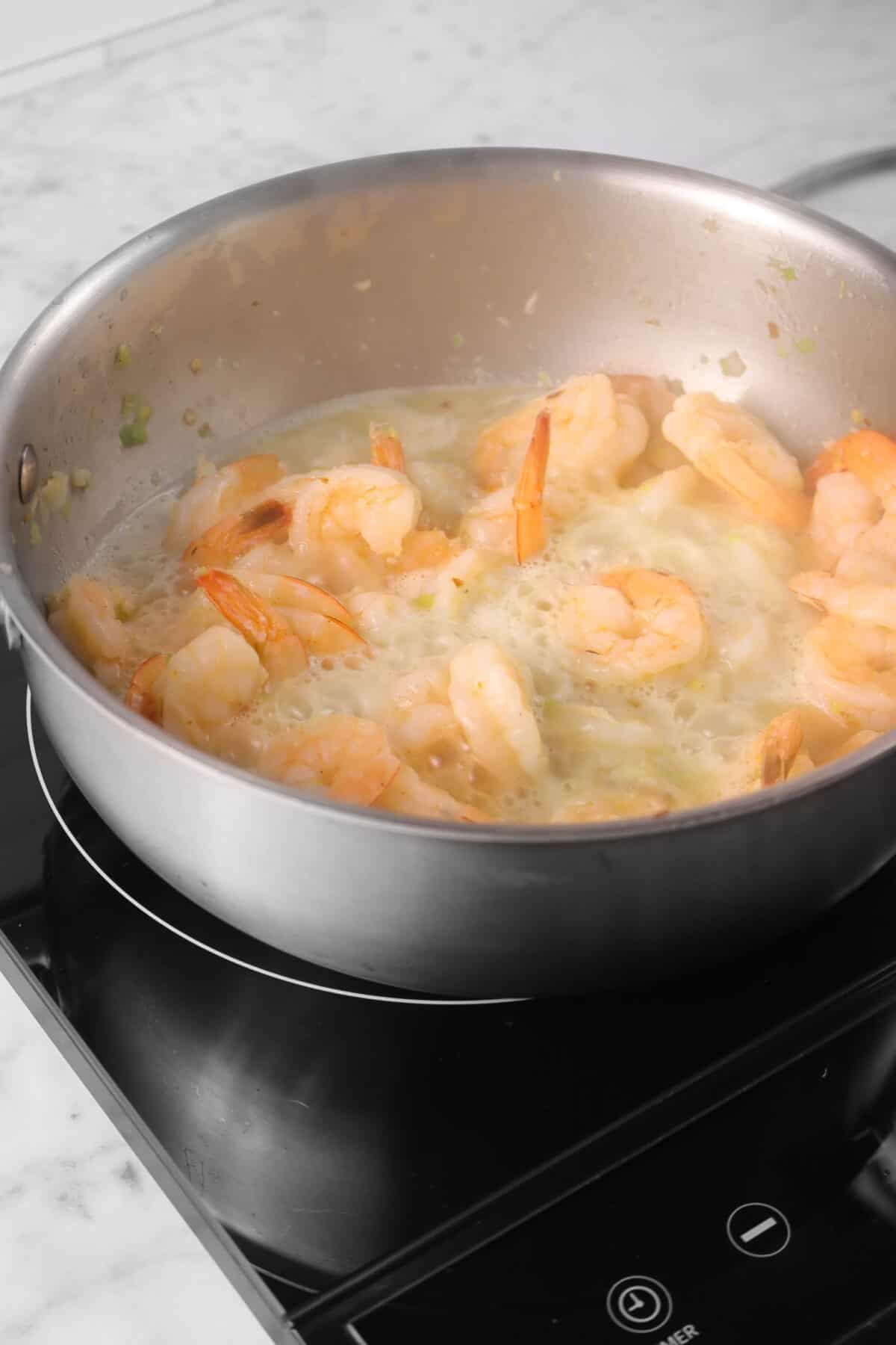 white wine boiling in a pot with shrimp scampi