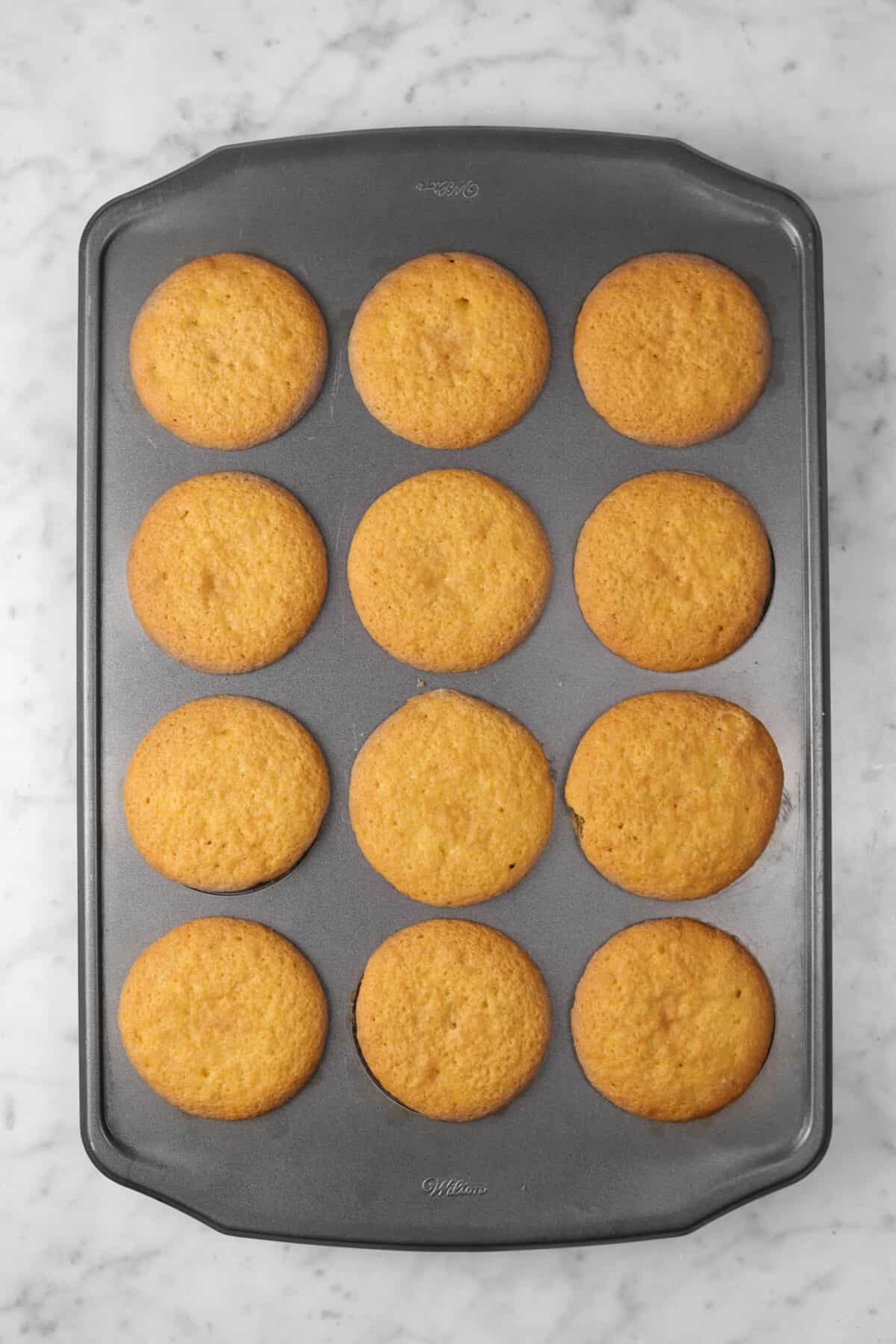Twelve baked butterbeer cupcakes in a pan