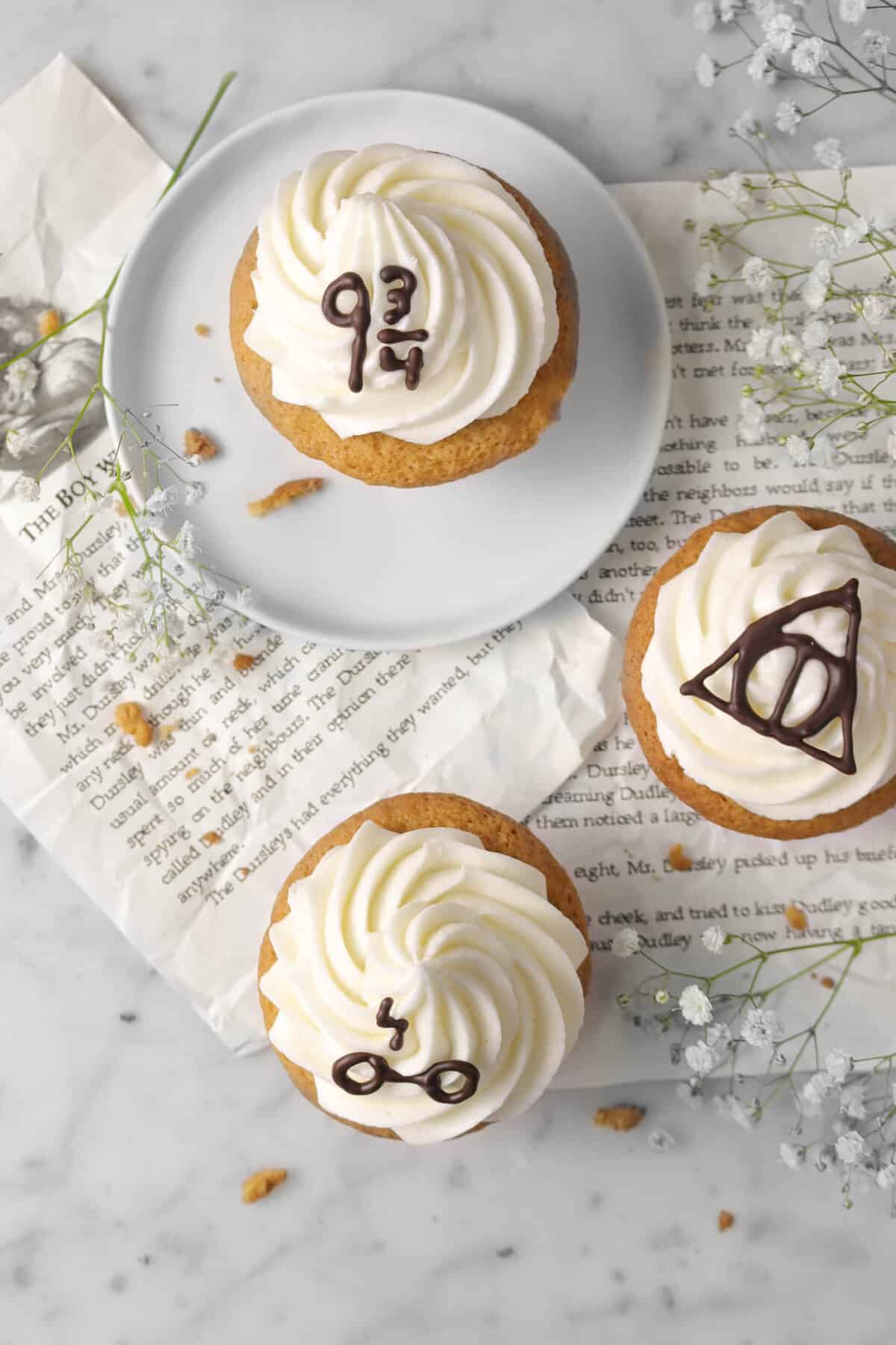 overheat shot of three cupcakes on harry potter book pages with flowers