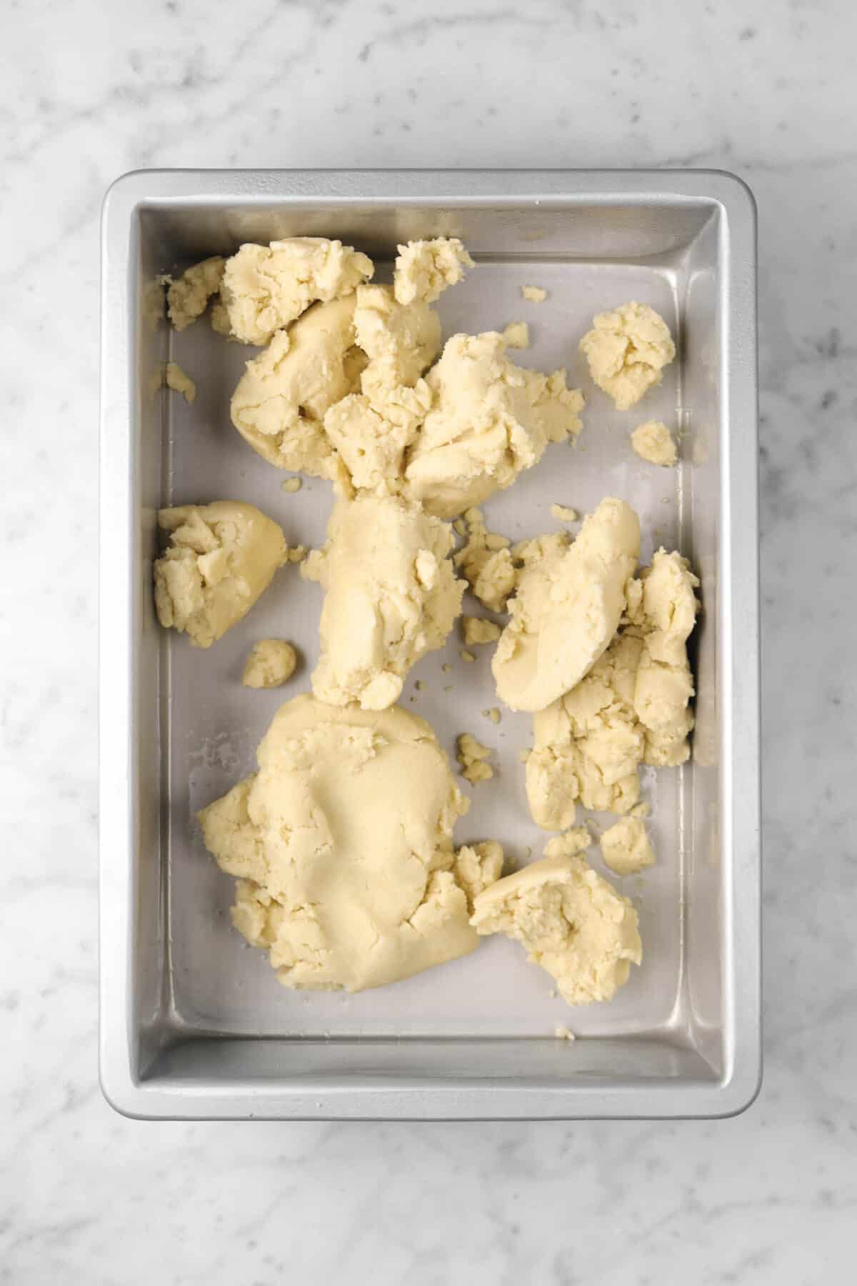 shortbread dough crumbled in a cake pan