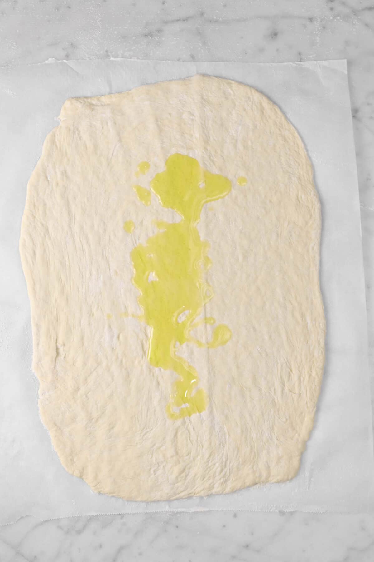 olive oil drizzled on rolled out pizza dough