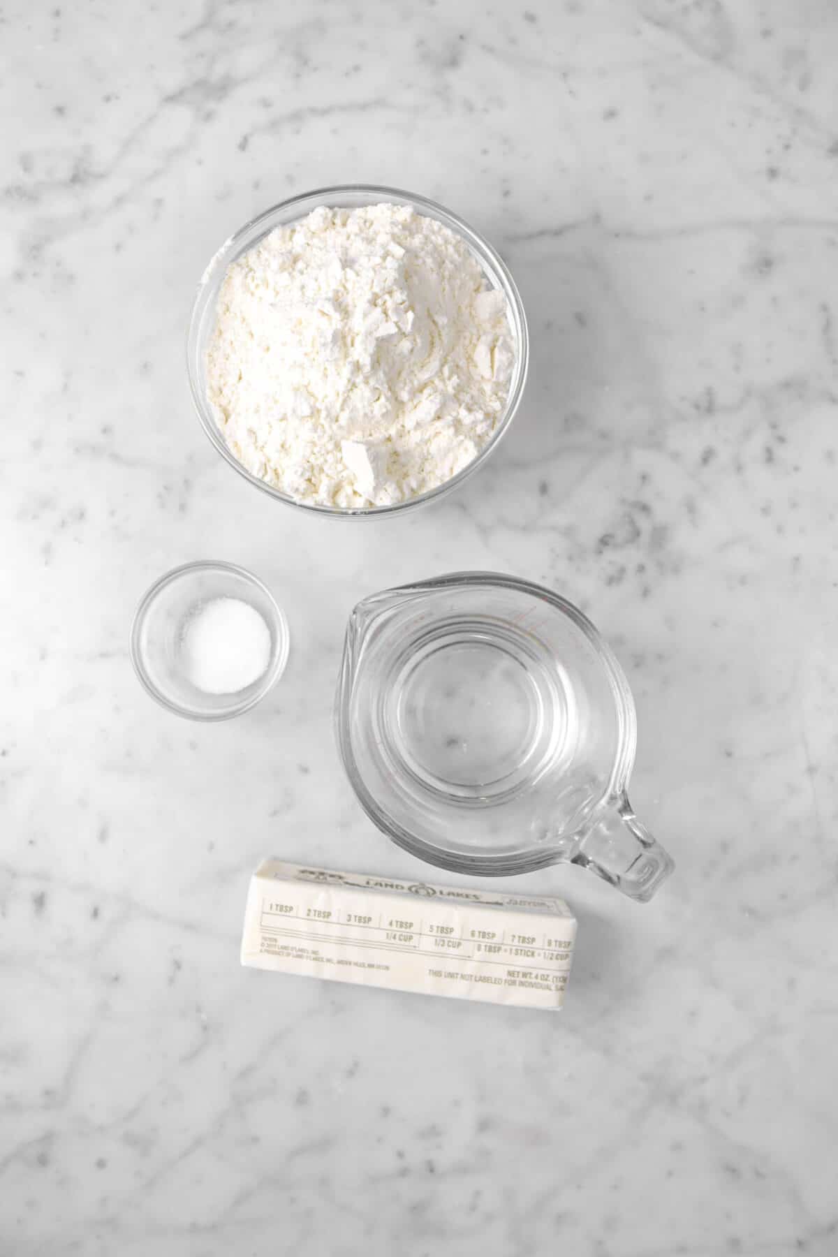 flour, salt, water, and butter on marble counter