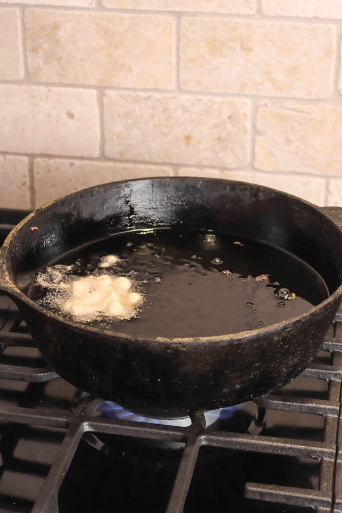 fritter batter being fried in oil