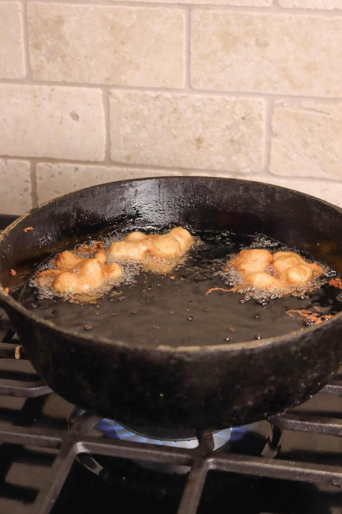 apple pie fritters being fried