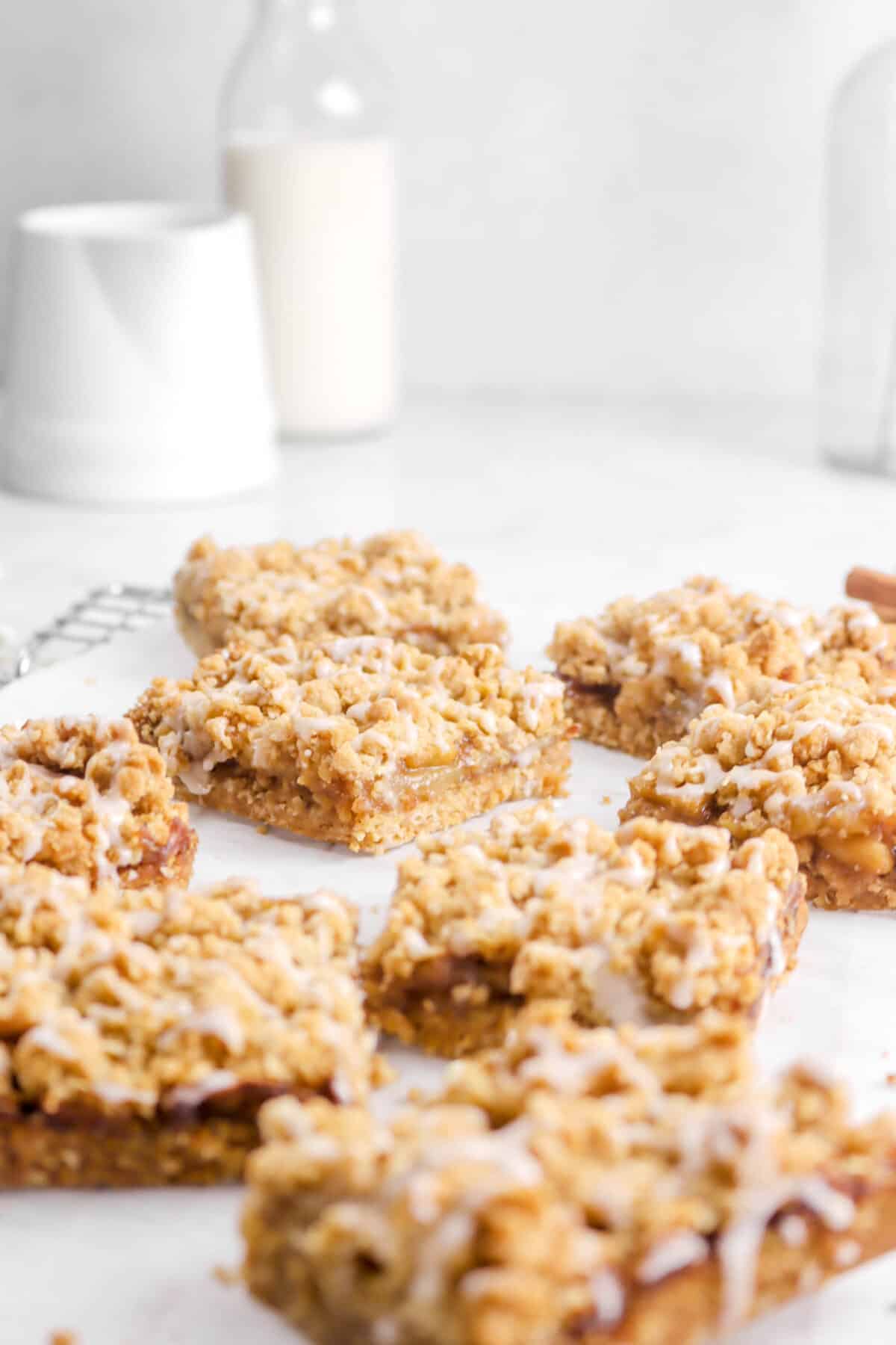 eight crumble bars on parchment paper with small white pitcher