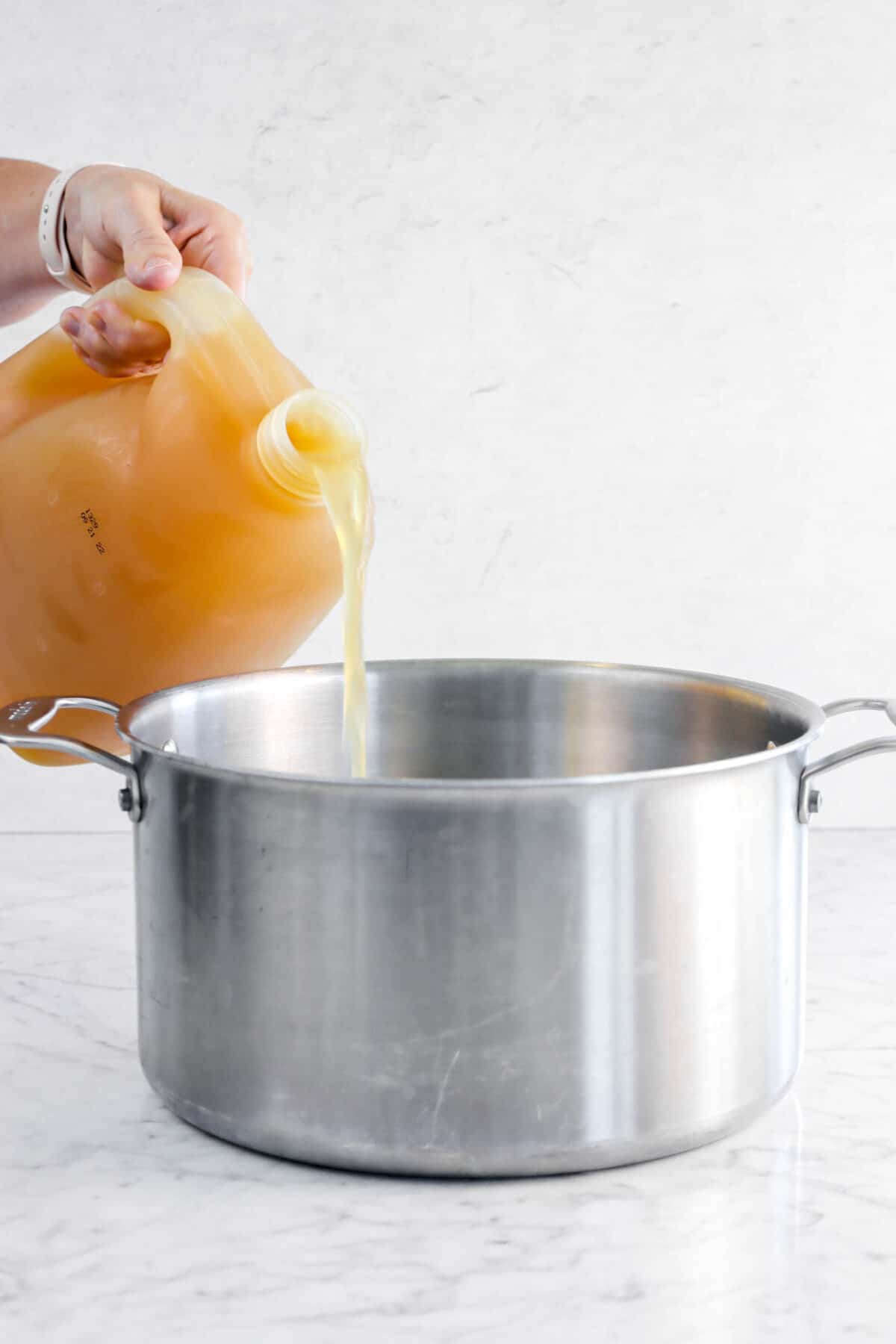 apple cider being poured into large pot