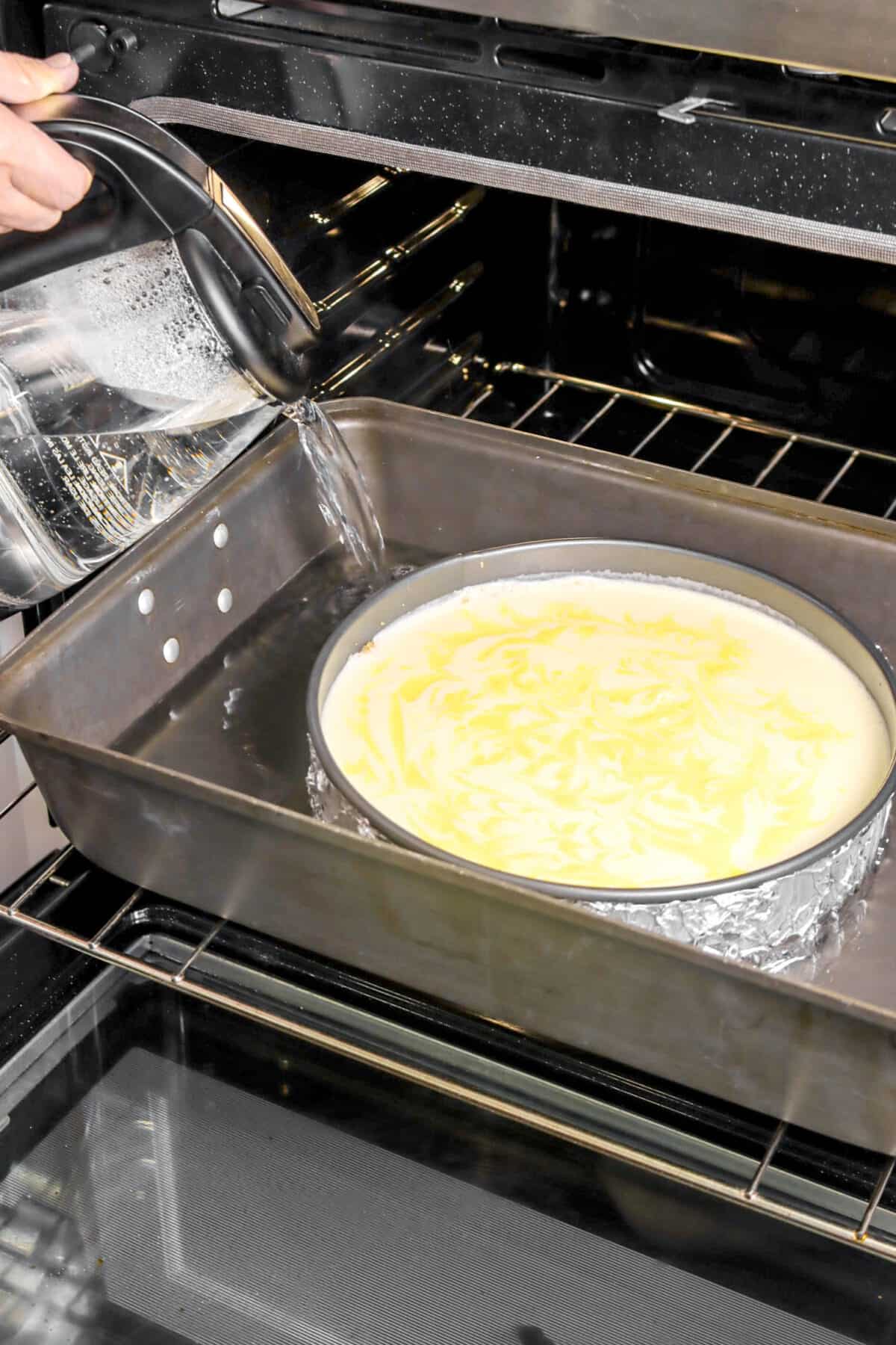 water being poured into pan with cheesecake inside