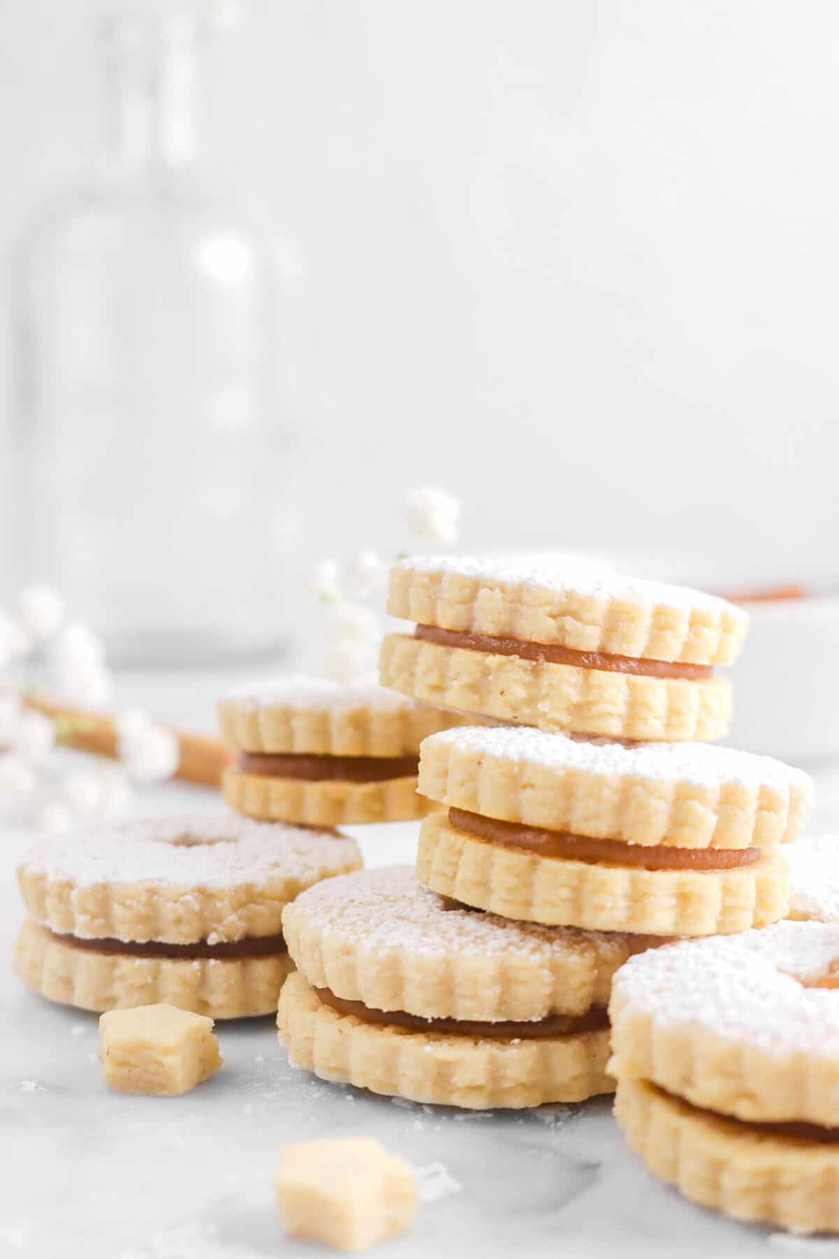 apple butter linzer cookies stacked with white flowers
