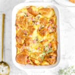 ham and cheese casserole with gold spoon and thyme sprigs