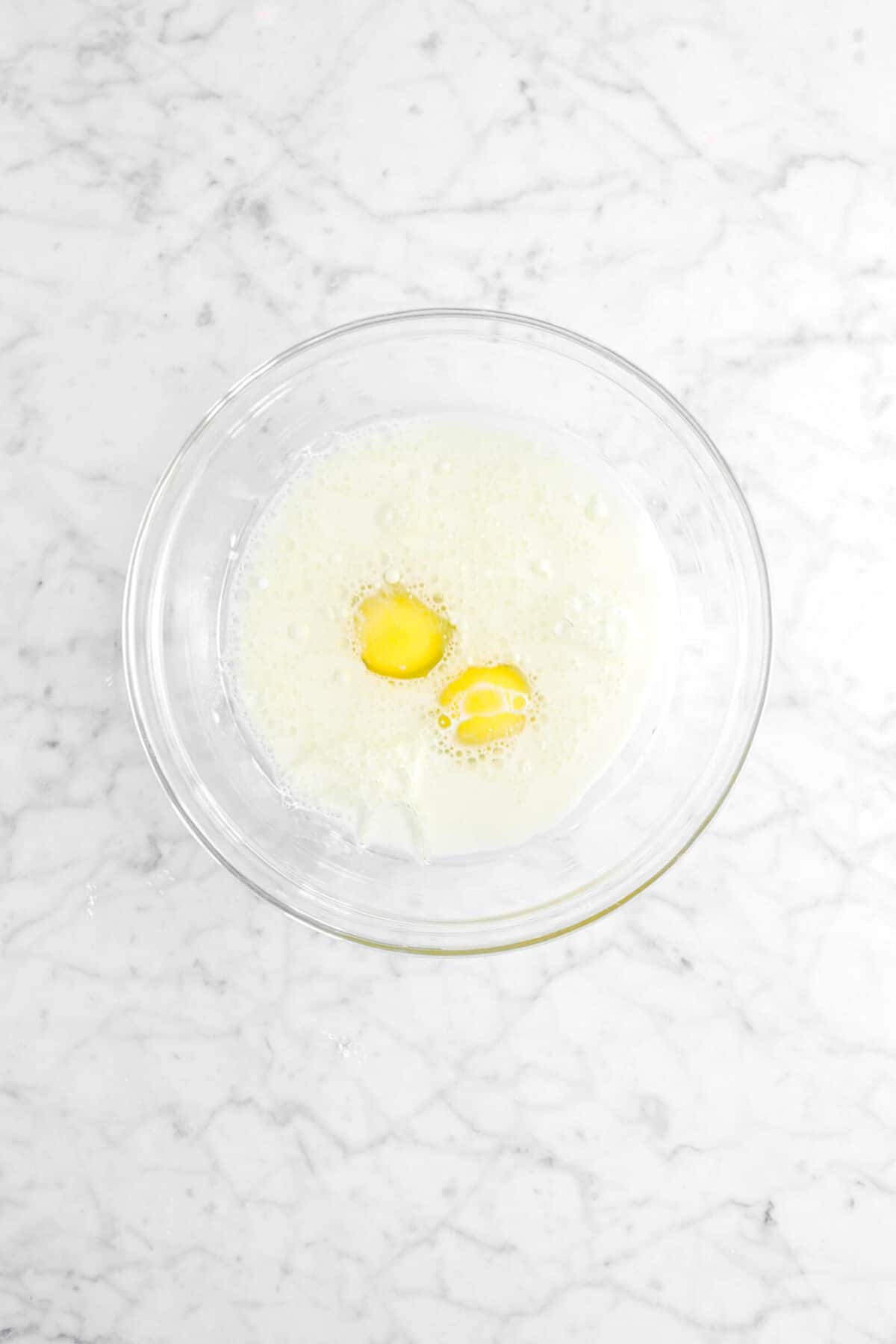 oil, eggs, and milk in glass bowl