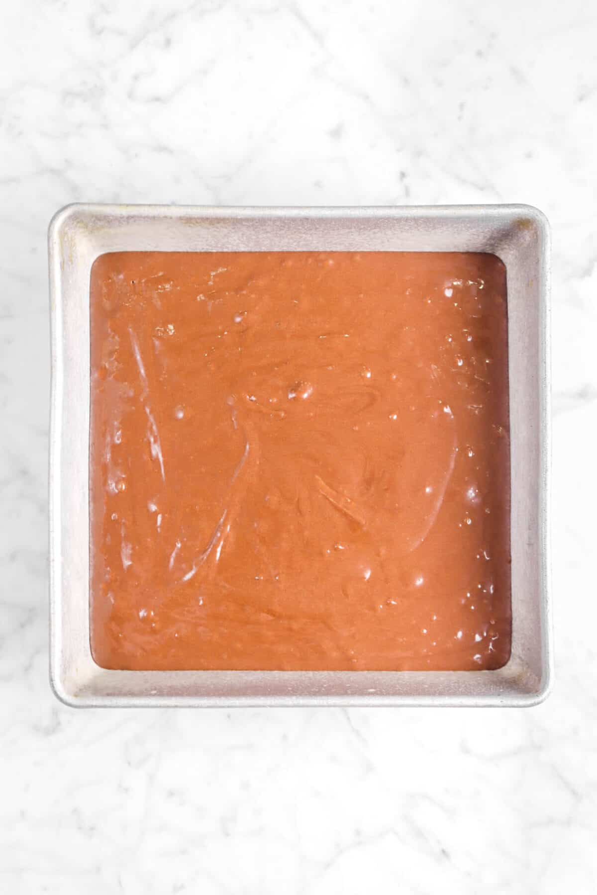 brownie batter in a greased square pan