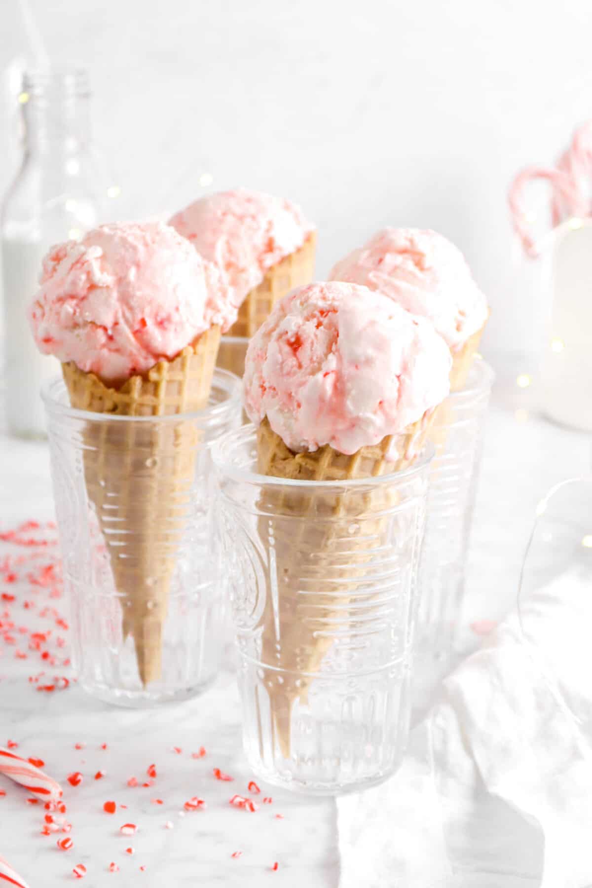peppermint ice cream in four glasses with fairy lights and a napkin