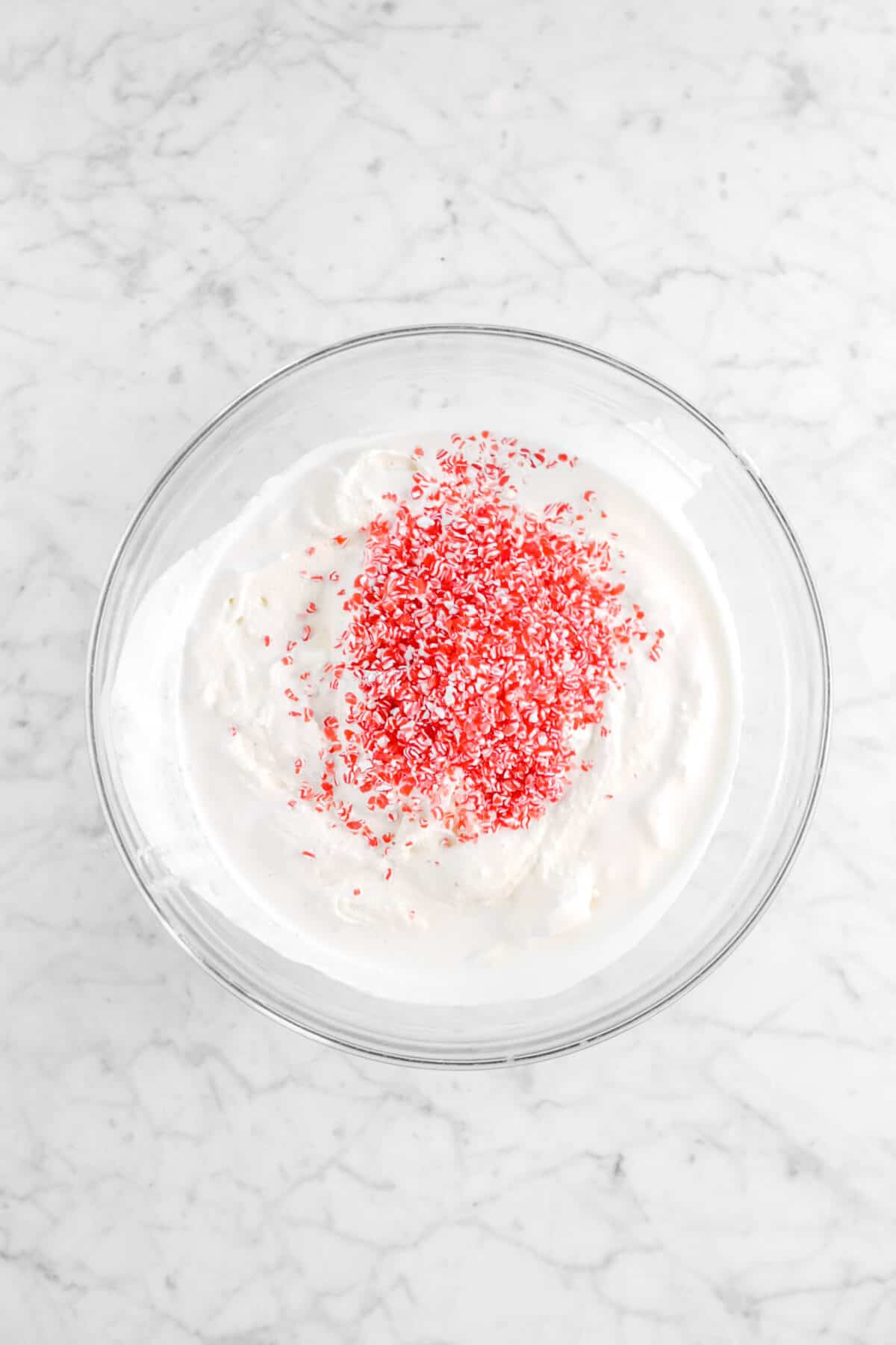 peppermint pieces added to ice cream in glass bowl