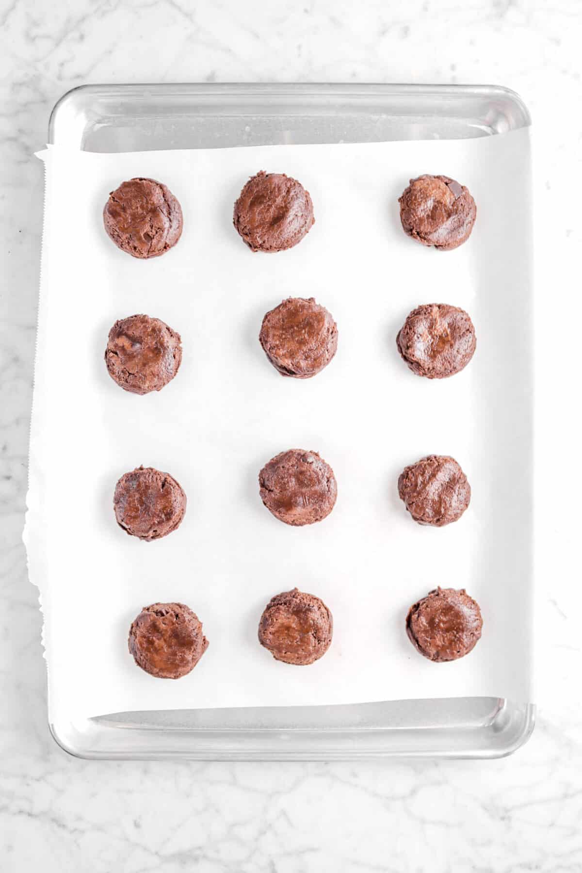 Twelve unbaked cookies on a baking sheet