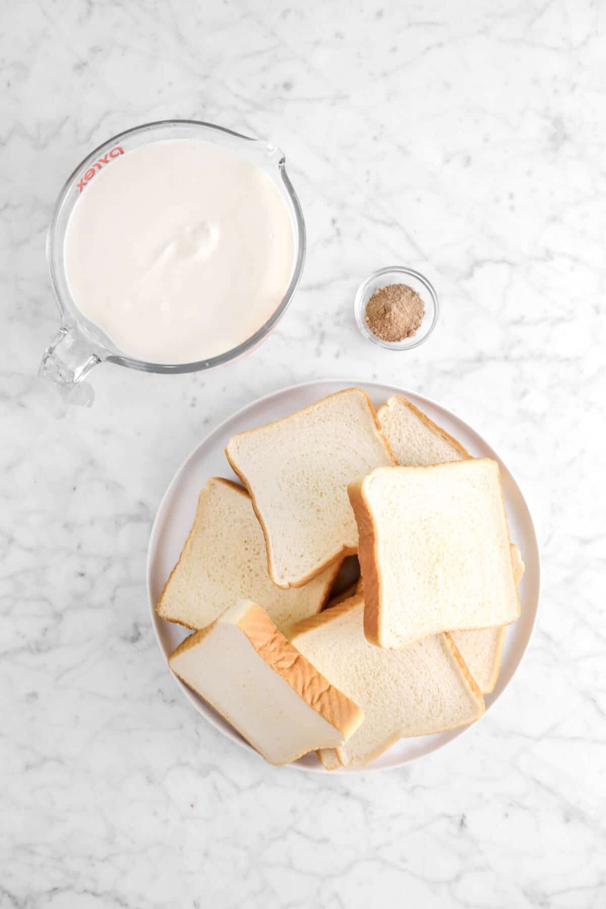 eggnog, nutmeg, and toast slices on marble counter