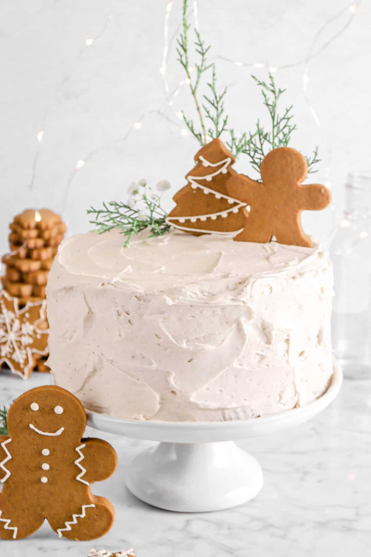 gingerbread layer cake with two cookies on top and greenery