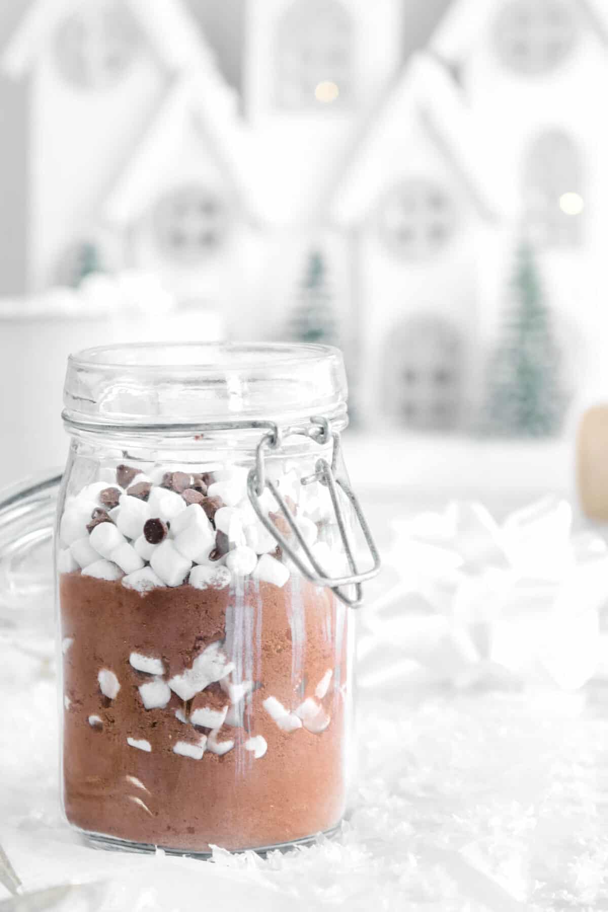 close up of cocoa mix in a jar with houses behind