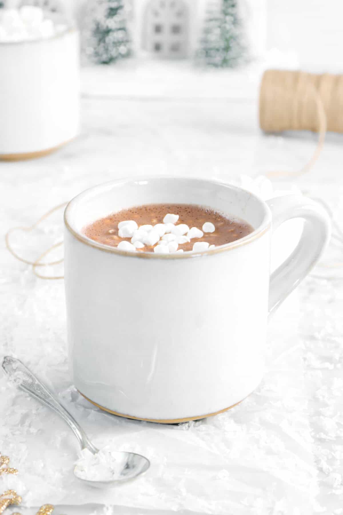 hot cocoa in a large mig with a spoon and marshmallows