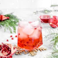 Pomegranate moscow mule with ornaments, greenery, fairy lights, and pomegranate wedge